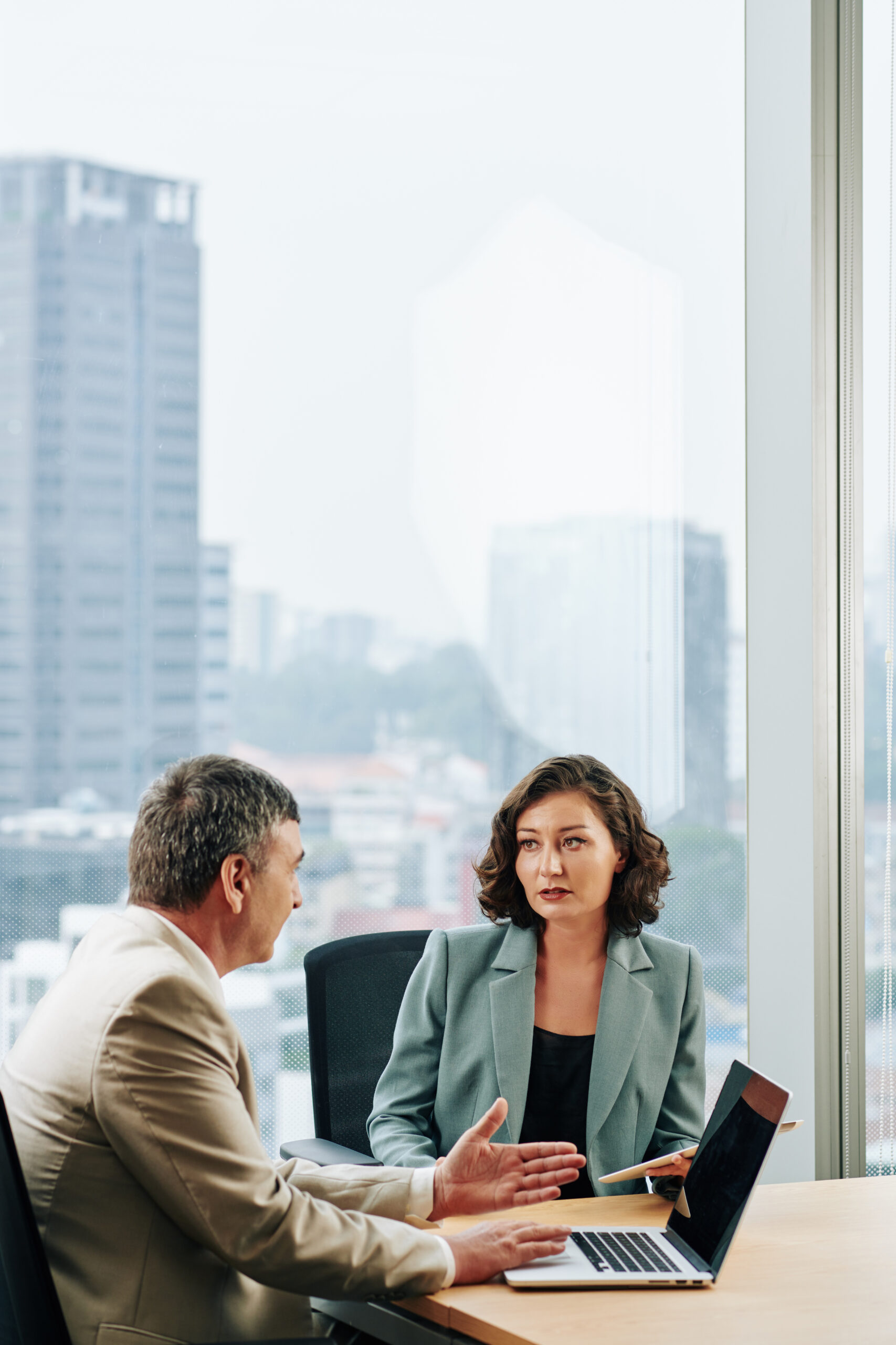 Serious big company CEO and COO discussing strategy of development at meeting